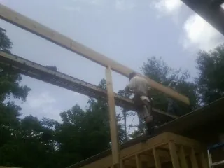 Carpenter setting a ridge beam over a new addition frame — Ice Dam Removal by Roofing Brothers in Lincolnshire