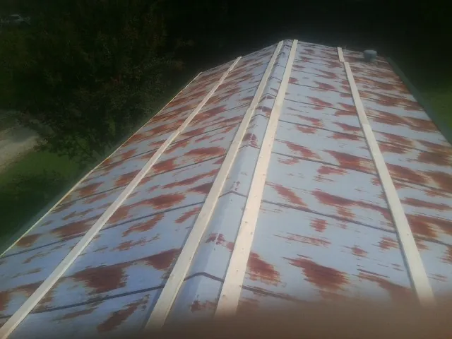 Rusted metal roof panels with new wood purlins before replacement — Storm Damage Roof Repair in Lincolnshire by Roofing Brothers