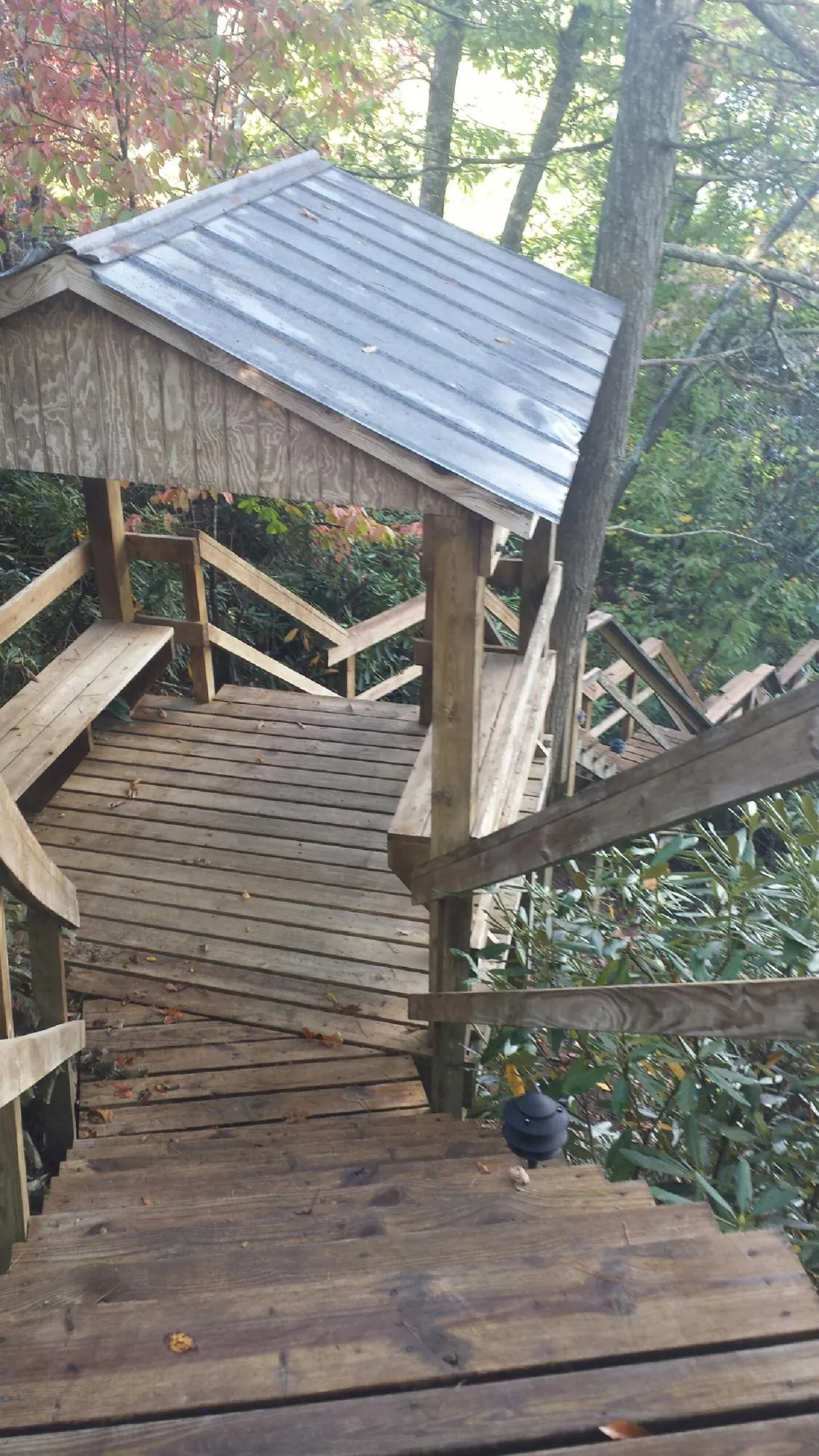 Metal roofed shelter over wooden steps on a wooded walkway — Skylight Repair & Installation work by our crew in Lincolnshire