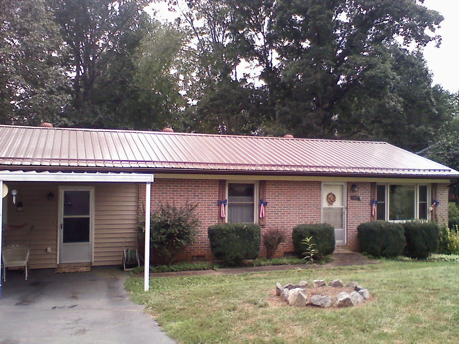 Bronze metal roof and carport on a brick ranch home — Roof Repair work by our crew in Lincolnshire